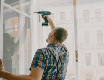 a construction worker installing a new window in a house