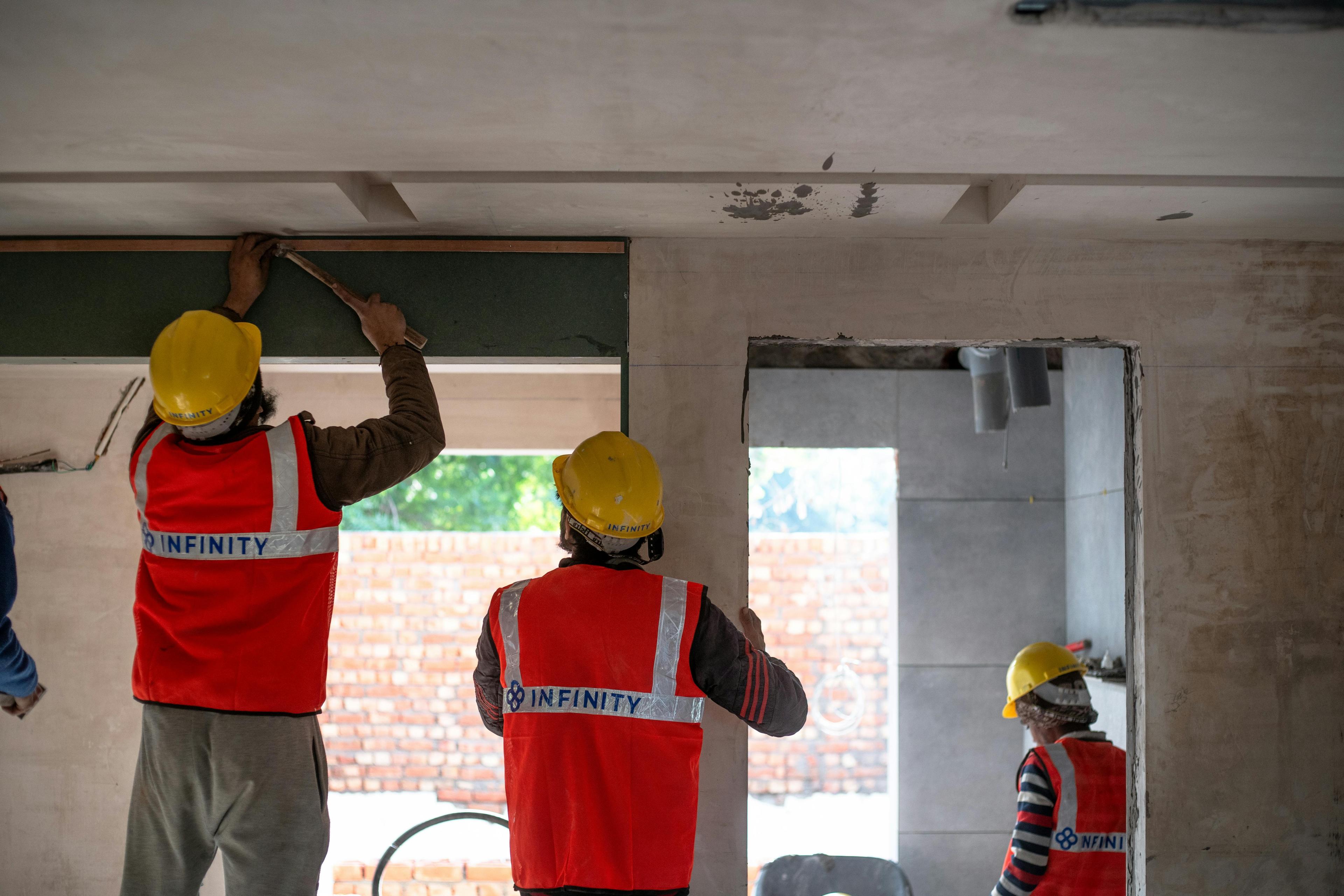 three construction workers safely working together