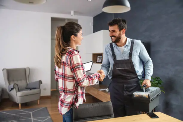 A man and woman shaking hands in an office.