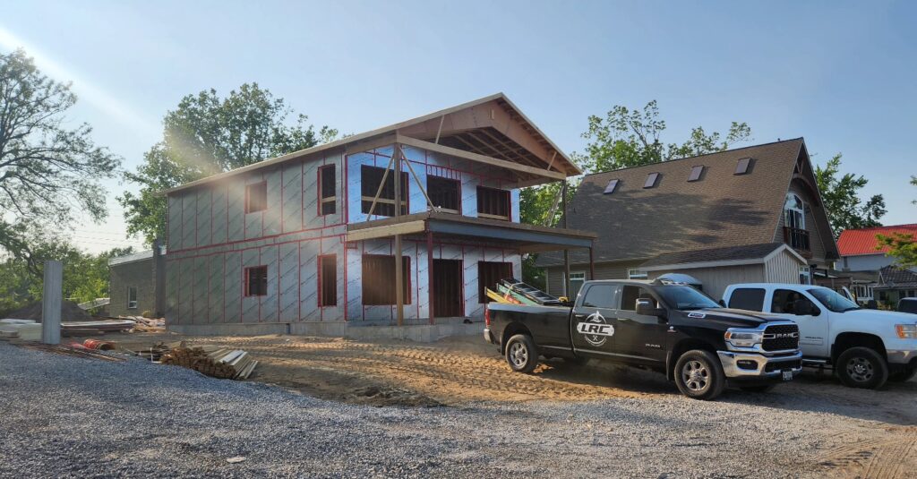 a house under construction with an LRC construction pickup truck out front