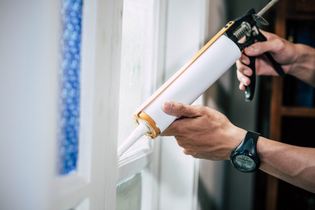 construction worker sealing energy efficient windows